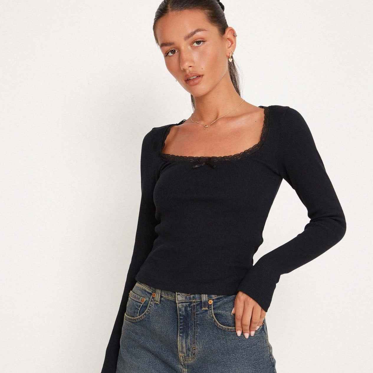 Dames top met ribstructuur, kanten rand en strikdetail